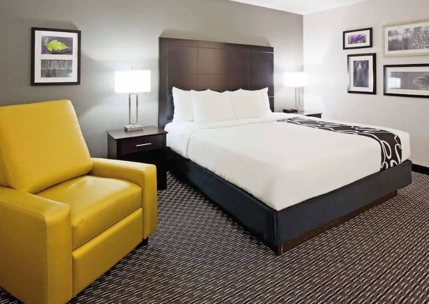 bedroom with cozy armchar and bed at La Quinta Inn by Wyndham Oshkosh, Wisconsin