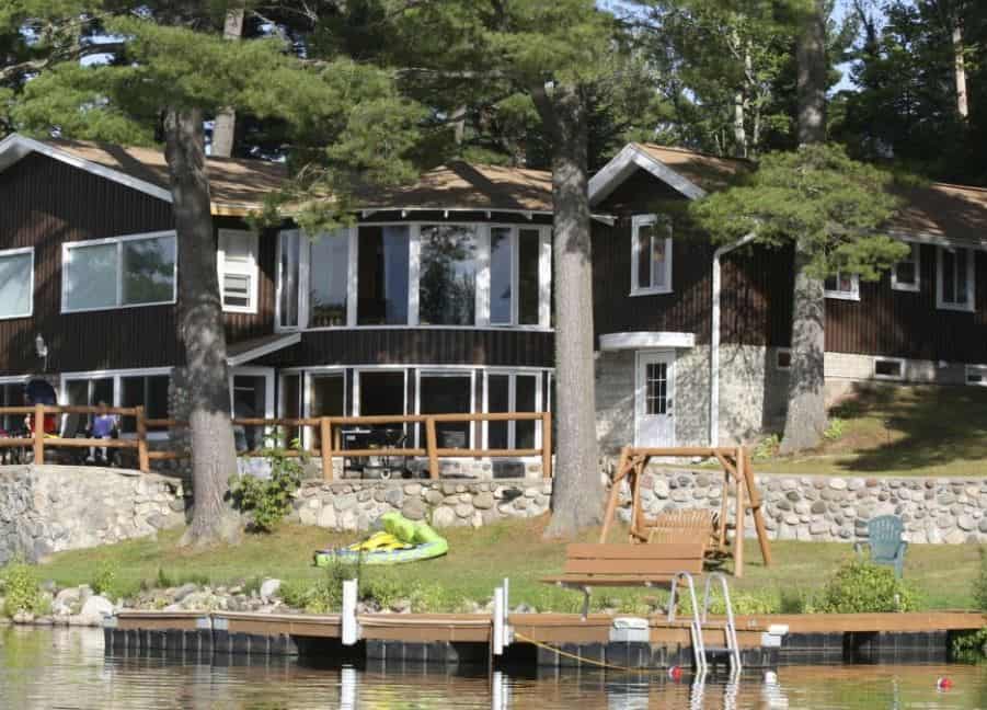 exterior of the Driftwood Lodge with playing area and lake in minocqua wisconsin
