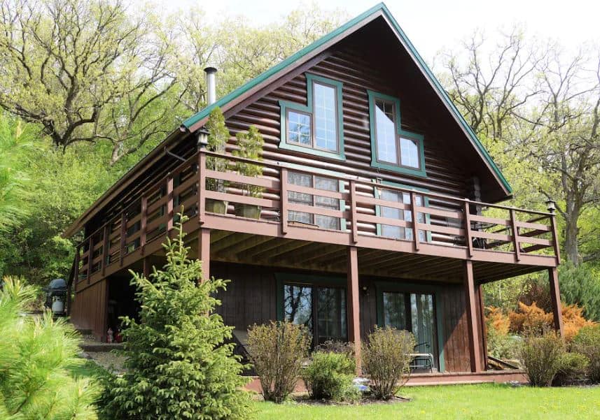 exterior of the rustic log cabin in Wisconsin with green areas surrouding it - 15 Best Family Cabins in Wisconsin