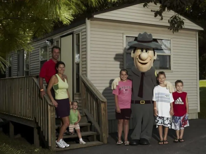 family in front of a cabin at Yogi Bears Jellystone Park Resort Wisconsin Dells - 10 Great Pet-Friendly Resorts in Wisconsin Dells