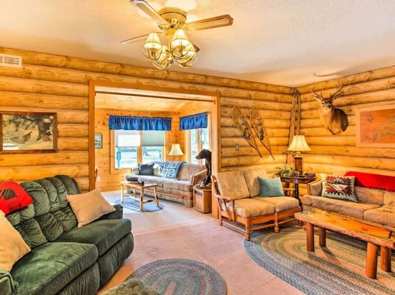 rustic interior with wooden walls and sofas at one of the best cozy cabins in Wisconsin