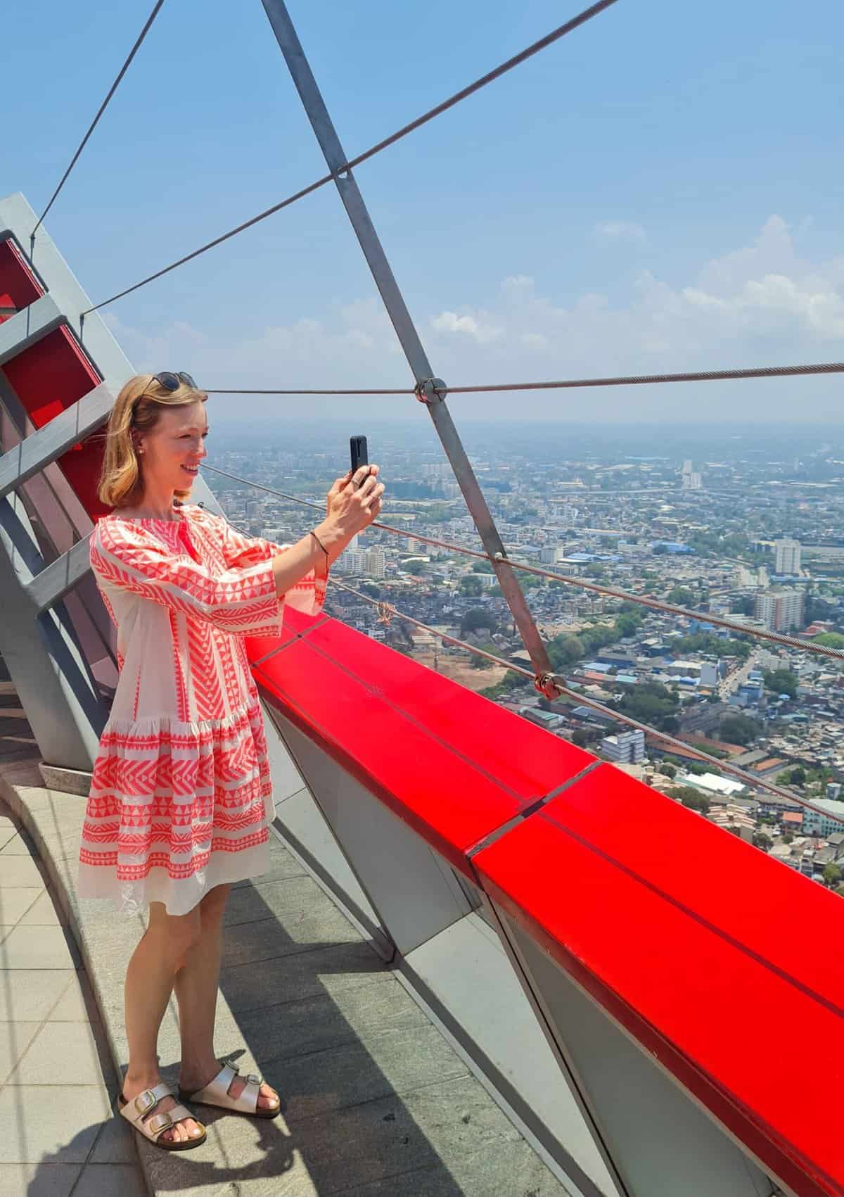 travel blogger using phone during traveling with a high of the city from atop