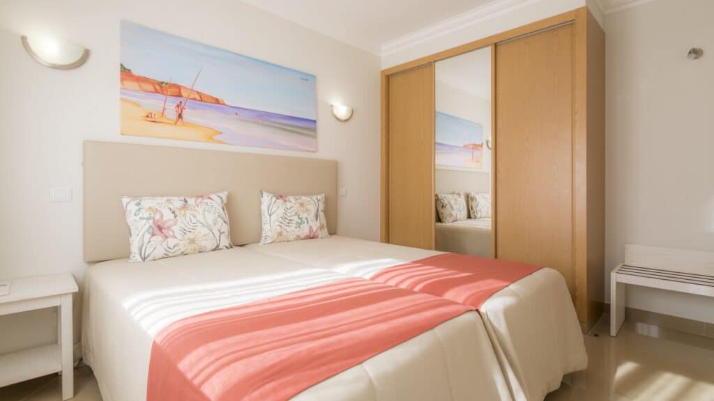 hotel room with large double bed and wardrobe as well as large colorful painting