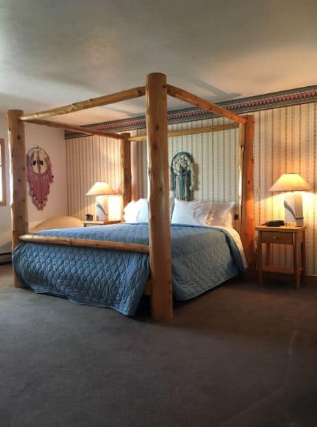 a rustic bedroom with a wooden bed at the White Birch Inn Wisconsin - 12 Best Pet-Friendly Resorts in Wisconsin