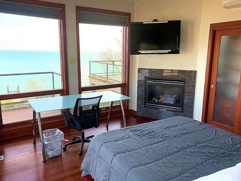 bedroom with fire place an office desk and lake view at the The Retreat on Lake Michigan racine wisconsin - 15 Best Airbnbs in Racine, WI