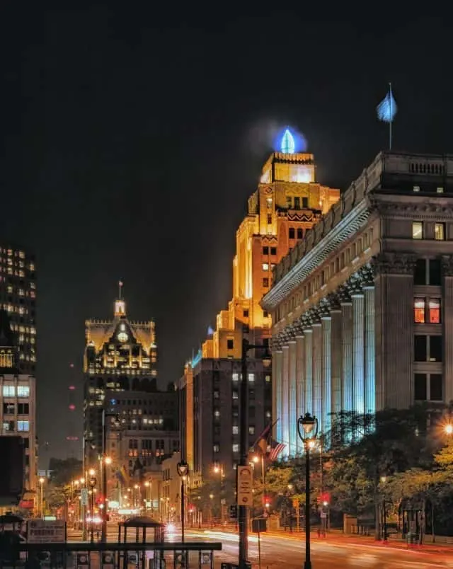 Fun Halloween things to do in Milwaukee, View of empty Milwaukee street and buildings lit up at night under a black sky