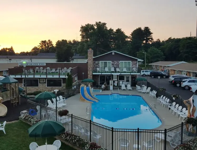 aerial view of the Black Hawk Motel & Suites with pool area with chairs and playground at sunset, Wisconsin Dells