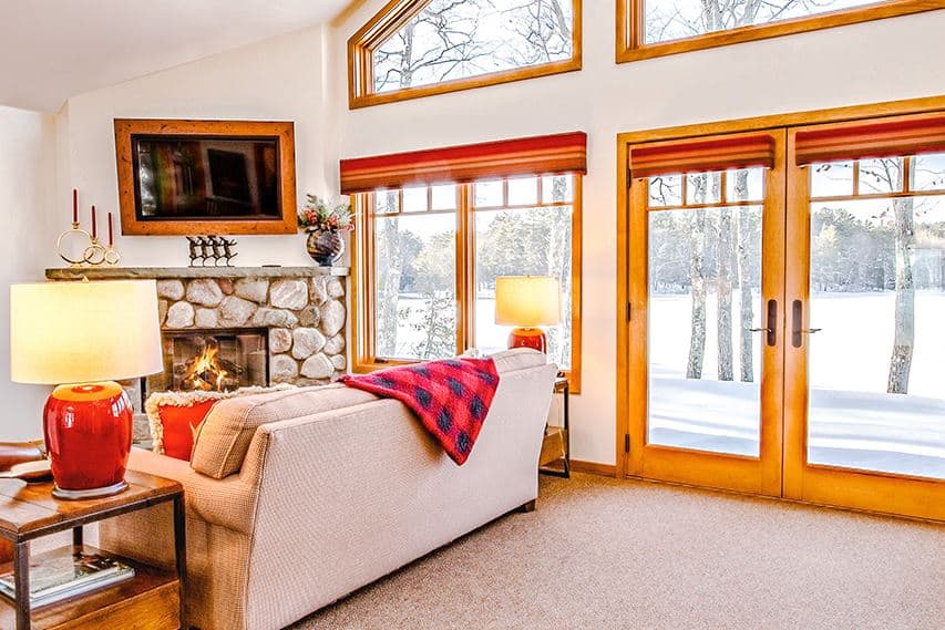 cozy living room with fire place and sofas with view of the lake at The Lodge at Manitowish Waters, Wisconsin