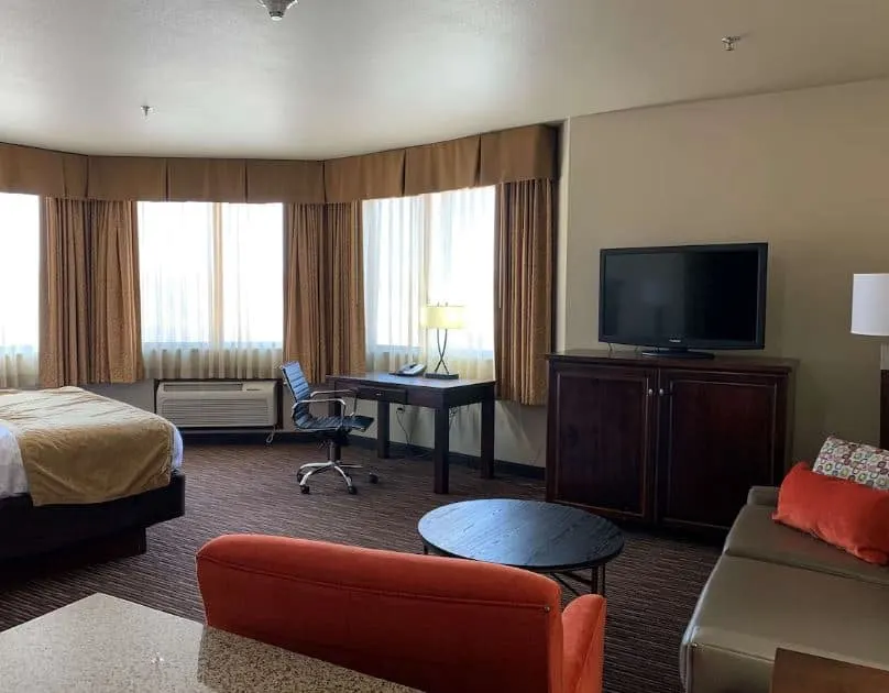 interior of a room with TV, desk, bed and sitting area at Radisson Hotel, River Falls, Wisconsin
