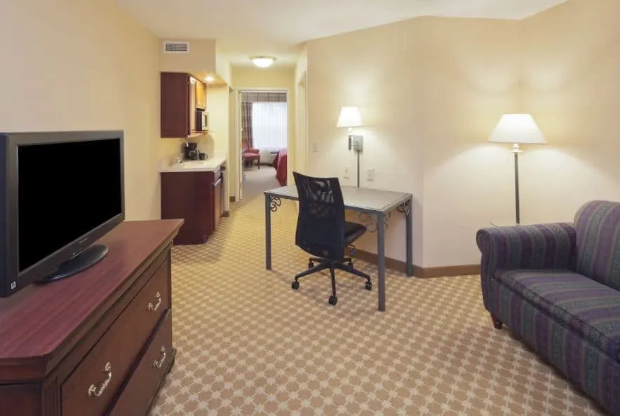 interior of a room with sofa, separate bedroom and TV at Country Inn & Suites by Radisson, Milwaukee West, Wisconsin