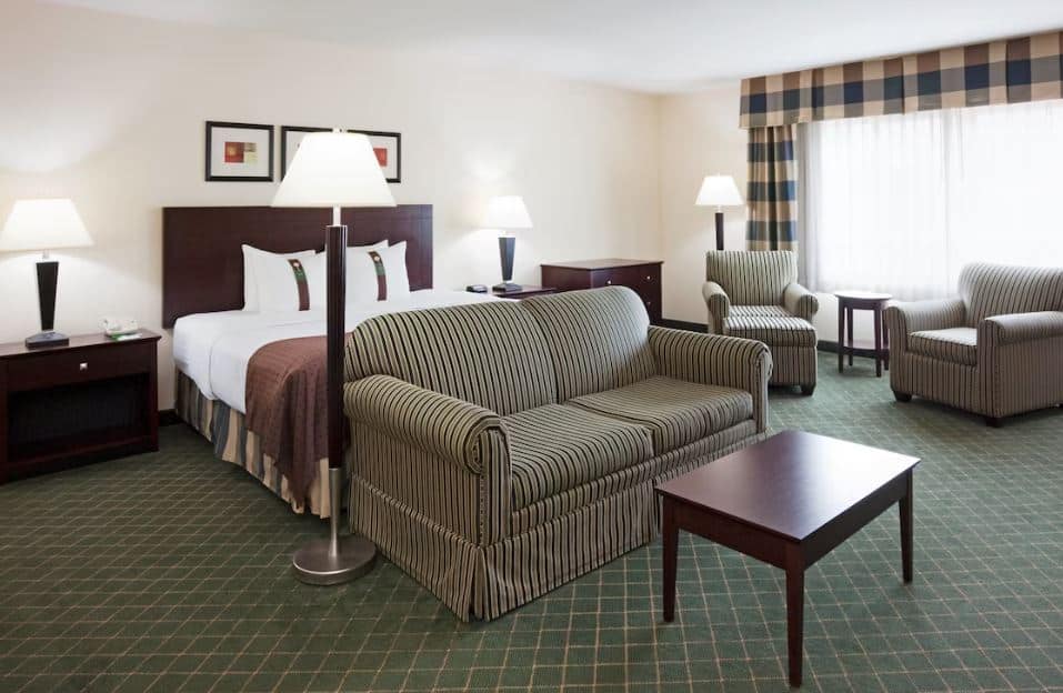 room with bed, sofas and tv at Holiday Inn Conference Ctr Marshfield, an IHG Hotel, Wisconsin