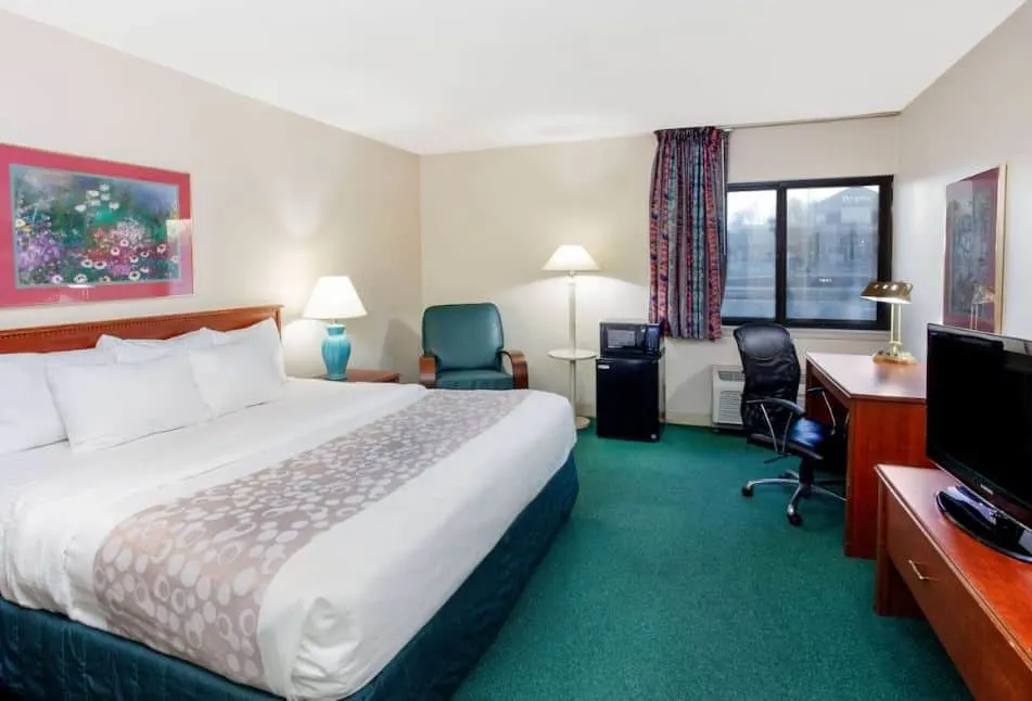 spacious bedroom with desk, TV and fridge at La Quinta Inn by Wyndham, Wausau, Wisconsin