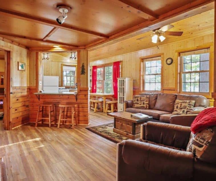 wooden living room with sofa and lake view at Eagle Waters Resort, Eagle River, Wisconsin
