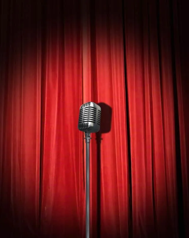 Milwaukee fall events, Single freestanding microphone from the 1950s era placed in front of a large red stage curtain with a single spotlight shining on it dramatically