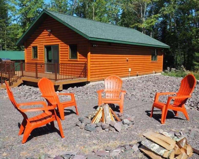 Log Cabin in Cornucopia, Lake Superior, Wisconsin surrounded by forest with a fire pit in front and deck