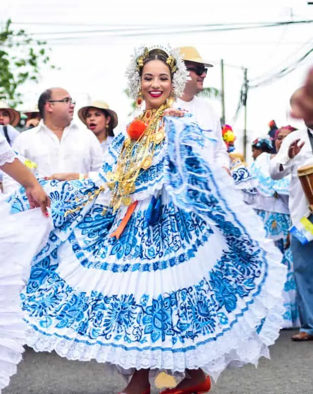 fall festivals near Milwaukee, Person in elaborate and ornate traditional dress with blue and white patterning standing amongst other similarly dressed members in a parade
