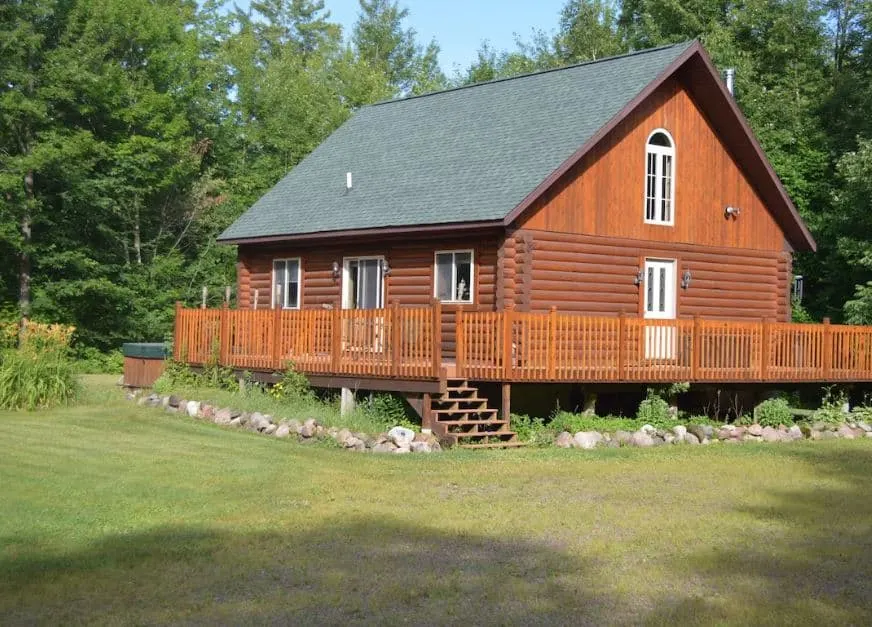 Ponderosa Pine Log Cabin in Ladysmith with wrap-around deck and forest in Wisconsin