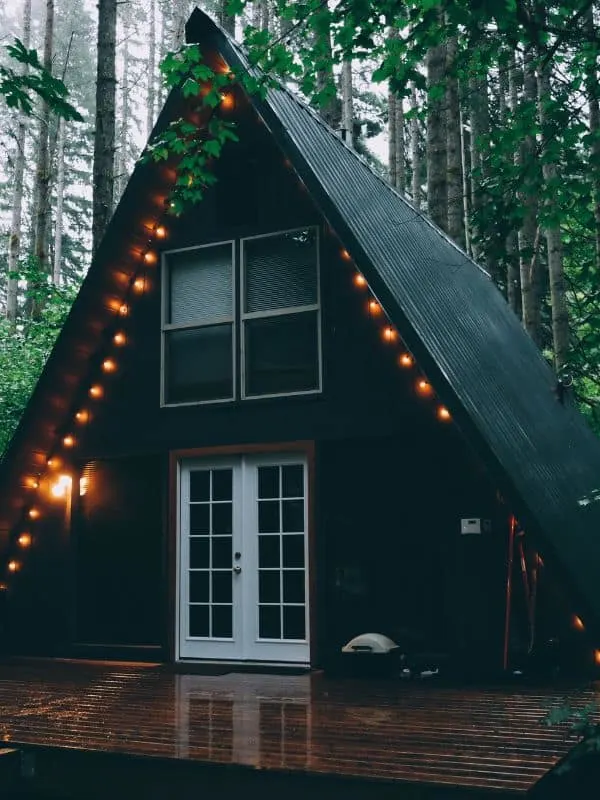 an A-frame house in Wisconsin dells with deck and lights in the woods