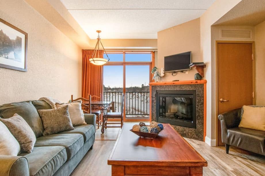 cozy living room with sofa, fire place and view at the Golf-Front Modern Condo with Fireplace, Wisconsin Dells