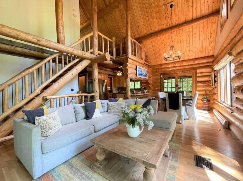 interior of the Log Cabin Retreat - Lake Geneva with sofa, dining area, open space kitchen and staircase