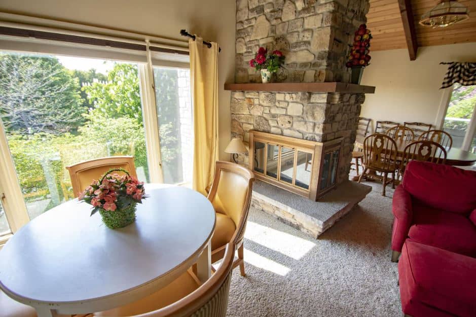 living room with dining table, sofa and fire place at Coachlite Inn, Sister Bay, Wi