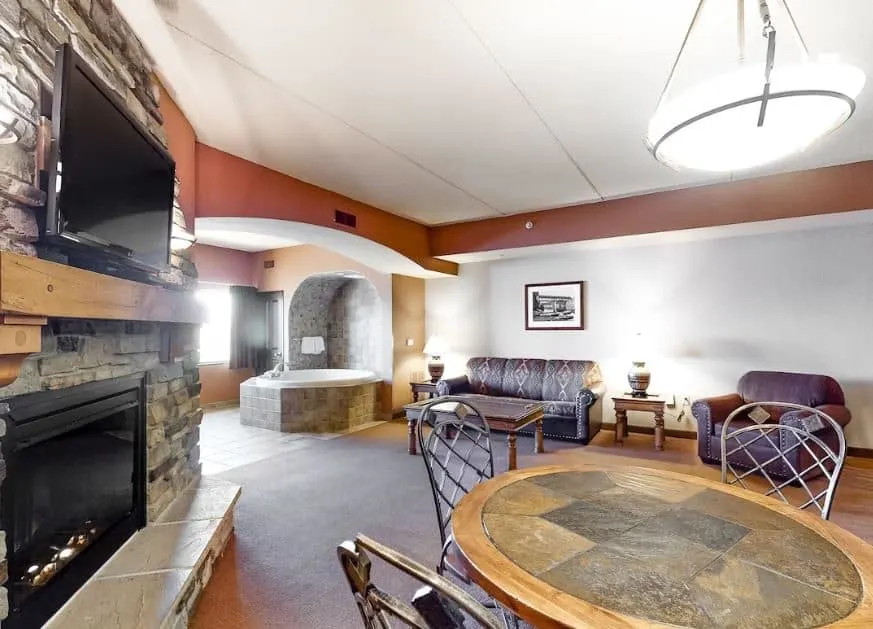 living room with sofa, desk, fire place and hot tub at the Family-Friendly Condo in Wisconsin Dells