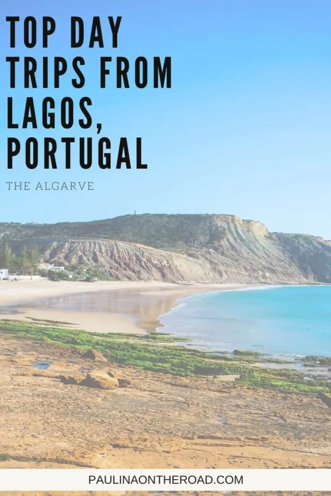 Pin with image of curved sandy beach sitting next to calm blue waters and surrounded by rolling grassy hills all under a clear azure blue sky, caption reads: Top Day Trips from Lagos, Portugal, The Algarve from paulinaontheroad.com
