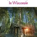 a pin with log cabin surrounded by forest, one of the best rustic cabin rentals in Wisconsin.