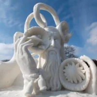 Best winter events in Wisconsin, Large psychedelic snow sculpture of an older bald man with a long beard adorned with several large bowls containing planets and stars with a looping spiral above it