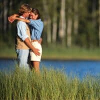 a couple hugging by a lake at one of the best Lake Geneva resorts for couples.