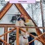 a pin with a couple and their dog in front of one of the best romantic winter cabins in Wisconsin.