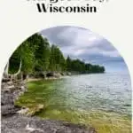 Pin with image of rocky coastline covered in green trees sitting next to a large body of water under a cloudy sky, caption reads: Fun Things to do in Sturgeon Bay, Wisconsin from paulinaontheroad.com