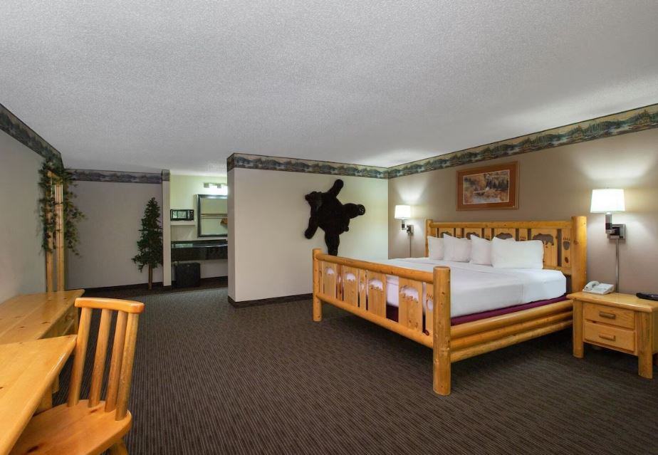 bedroom with bed and desk at the Cobblestone Hotel & Suites in Ladysmith, WI