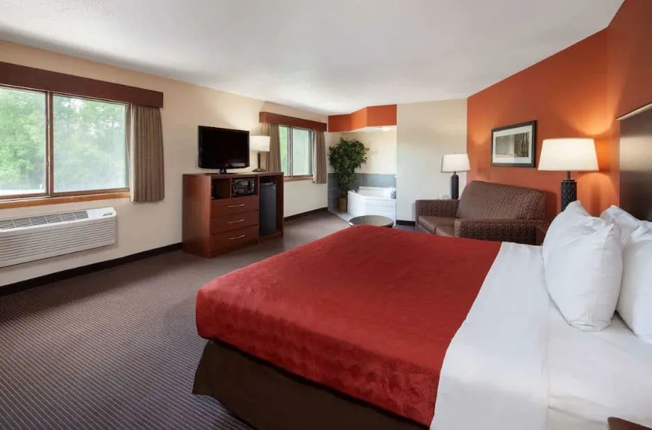 bedroom with hot tub and sofa at AmericInn by Wyndham in Ashland, WI