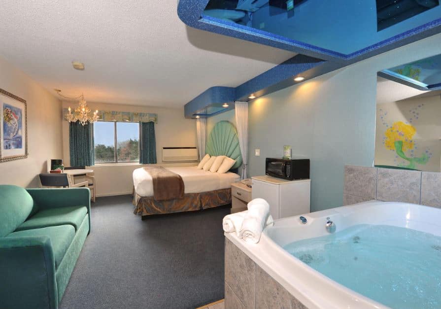 bedroom with hot tub, sofa and bed at Atlantis Family Waterpark Hotel, Wisconsin Dells