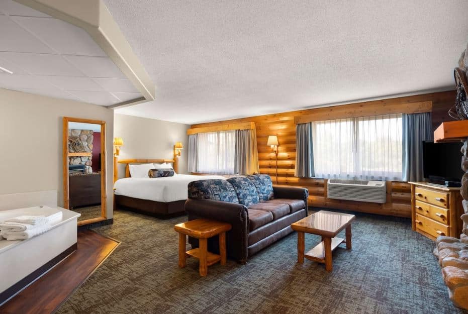 cozy room with bed, sofa and hot tub at the Best Western Northwoods Lodge in Siren, WI