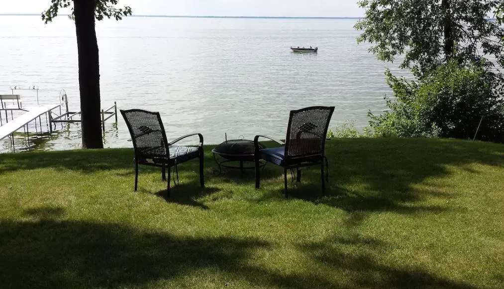 two chairs in front of the lake on the lawn of the Gorgeous Cabin on Lake Winnebago in Hilbert, WI