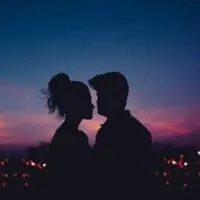 Most romantic things to do in Milwaukee Wisconsin, Silhouette of two people standing in front of the bright lights of a wide cityscape at dusk under a dark sky