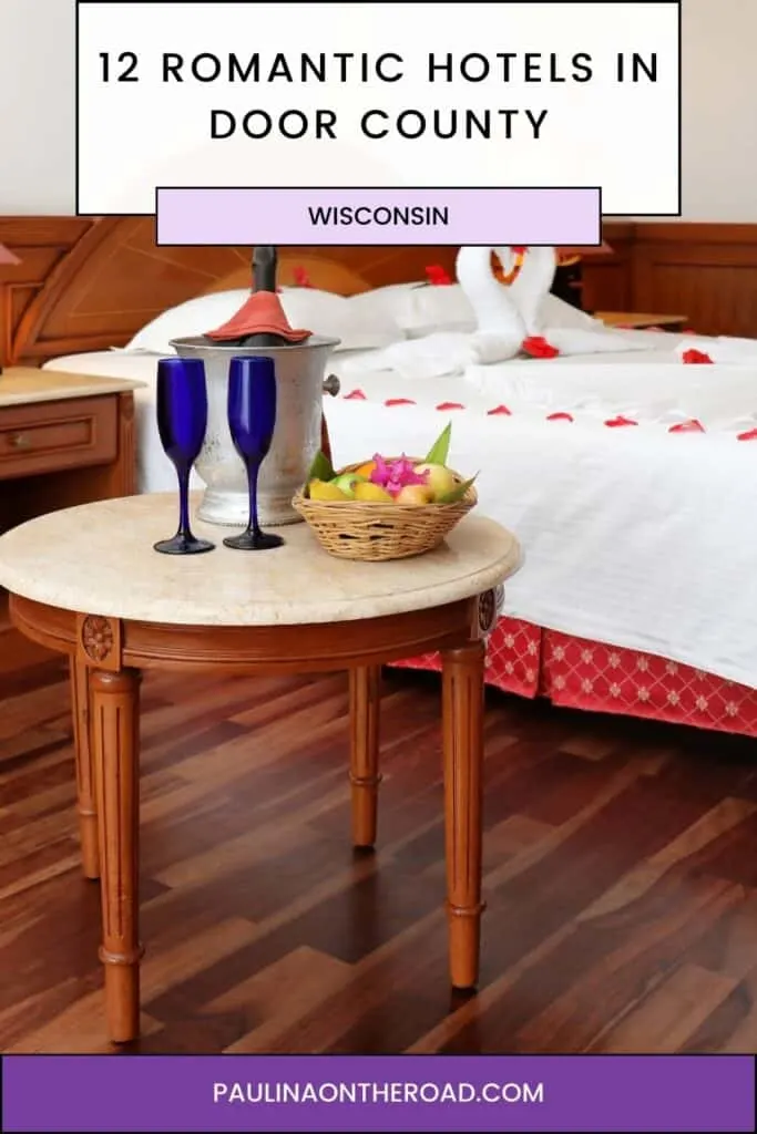 a pin with a bed decorated with roses and next to it 2 drinks at one of the most romantic hotels in Door County