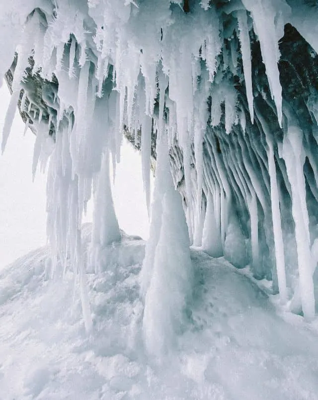 Where to go in Wisconsin Dells in January, A collection of frozen icicles hanging from the roof of an overhanging cave all the way to the snowy ground