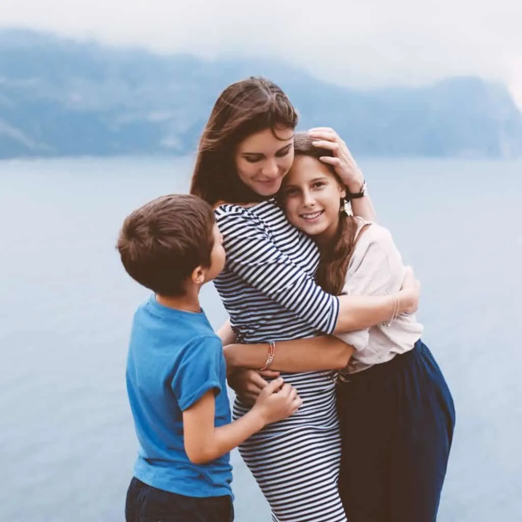 a mother with her daughter and son enjoying time by what seems like a lake