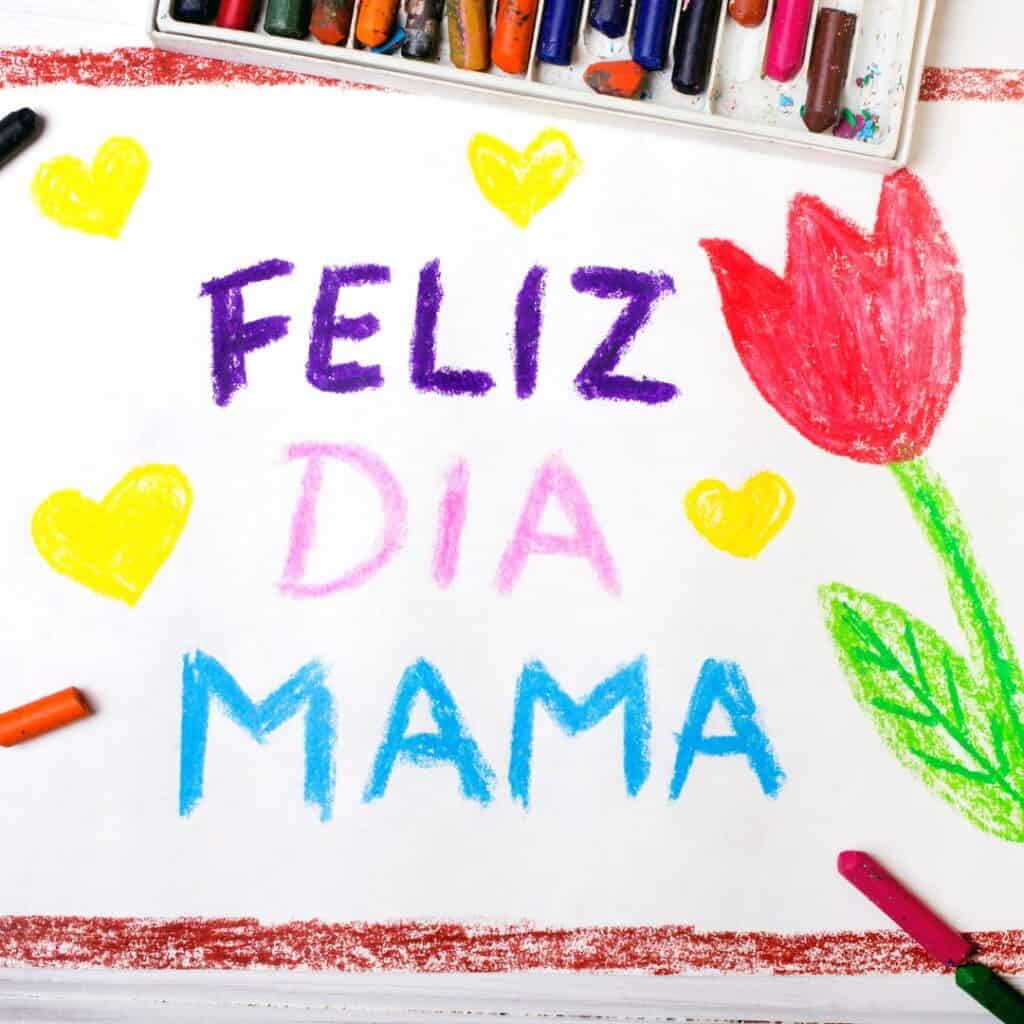 a paper art with a tulip and heart drawings and a message saying Feliz Dia Mama