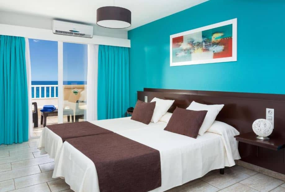 bedroom with balcony overlooking the sea at Aparthotel Los Dragos del Sur in Puerto de Santiago, Tenerife