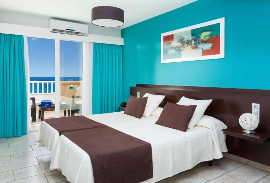 bedroom with balcony overlooking the sea at Aparthotel Los Dragos del Sur in Puerto de Santiago, Tenerife
