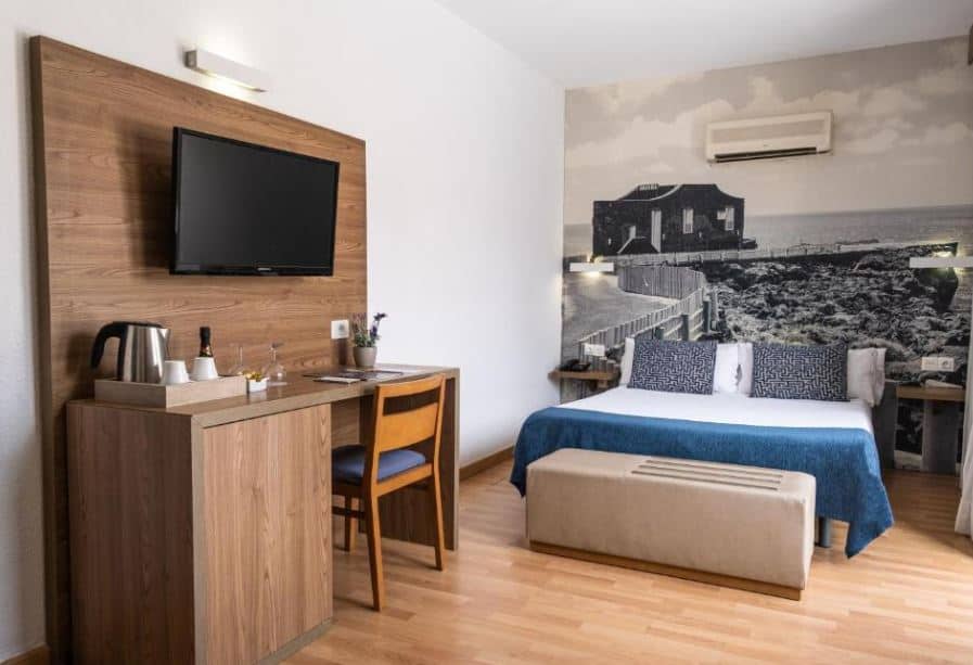 cozy room with bed, desk and TV at Hotel Adonis Plaza - Santa Cruz de Tenerife
