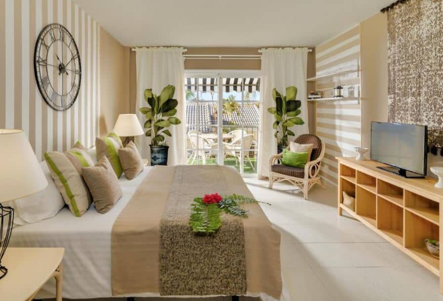 interior of a bedroom with bed, TV and balcony at Gran Oasis Resort in Playa de las Americas, Tenerife