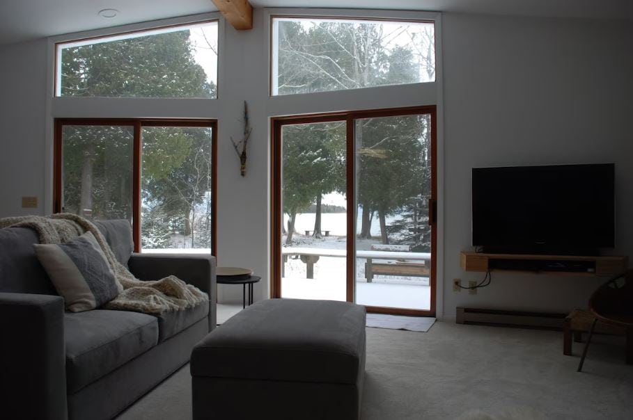 living room with sofa, TV and big windows at winter at the Lake-House With The Best View Of Cana Island - Baileys Harbor