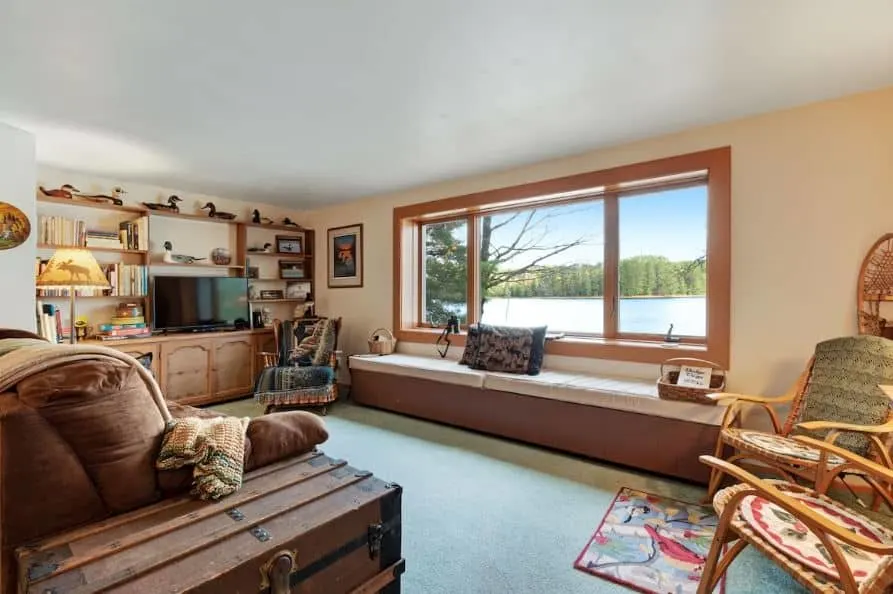 living room with sofa and lake view at the Lakefront cabin with fireplace in Eagle River Wisconsin - 15 Comfy Winter Cabin Rentals in Wisconsin