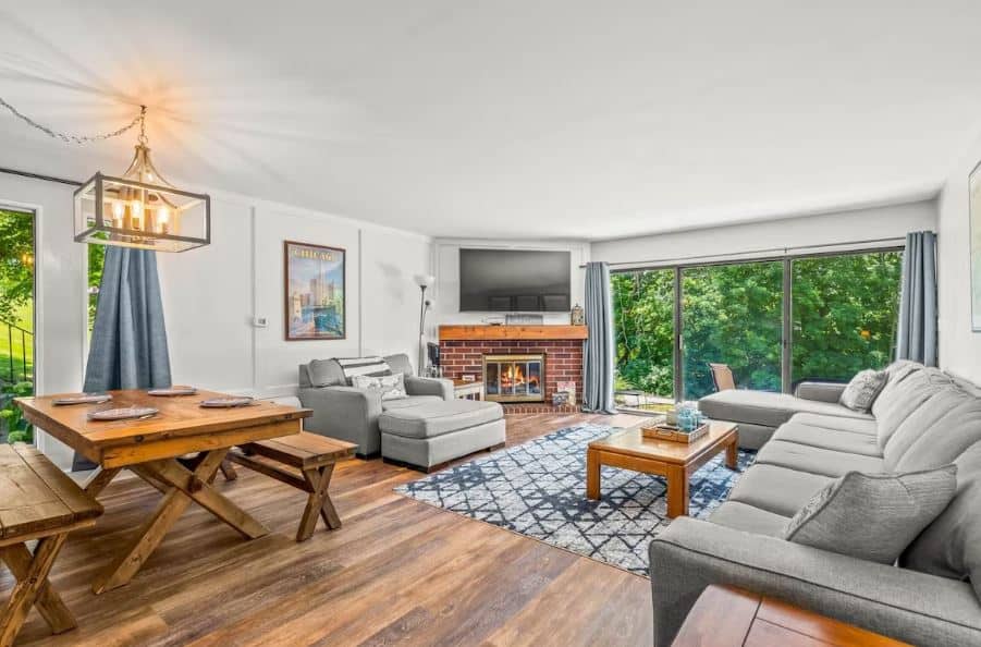 living room with sofa, dining table, fire place and access to balcony at Modern Lake Geneva Condo with Year-Round Views, Wisconsin