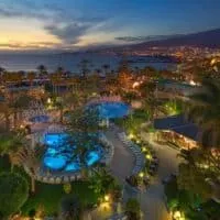 the grounds of H10 Las Palmeras in Playa de las Americas, Tenerife at night with pools and sea view, where to stay in tenerife in Winter